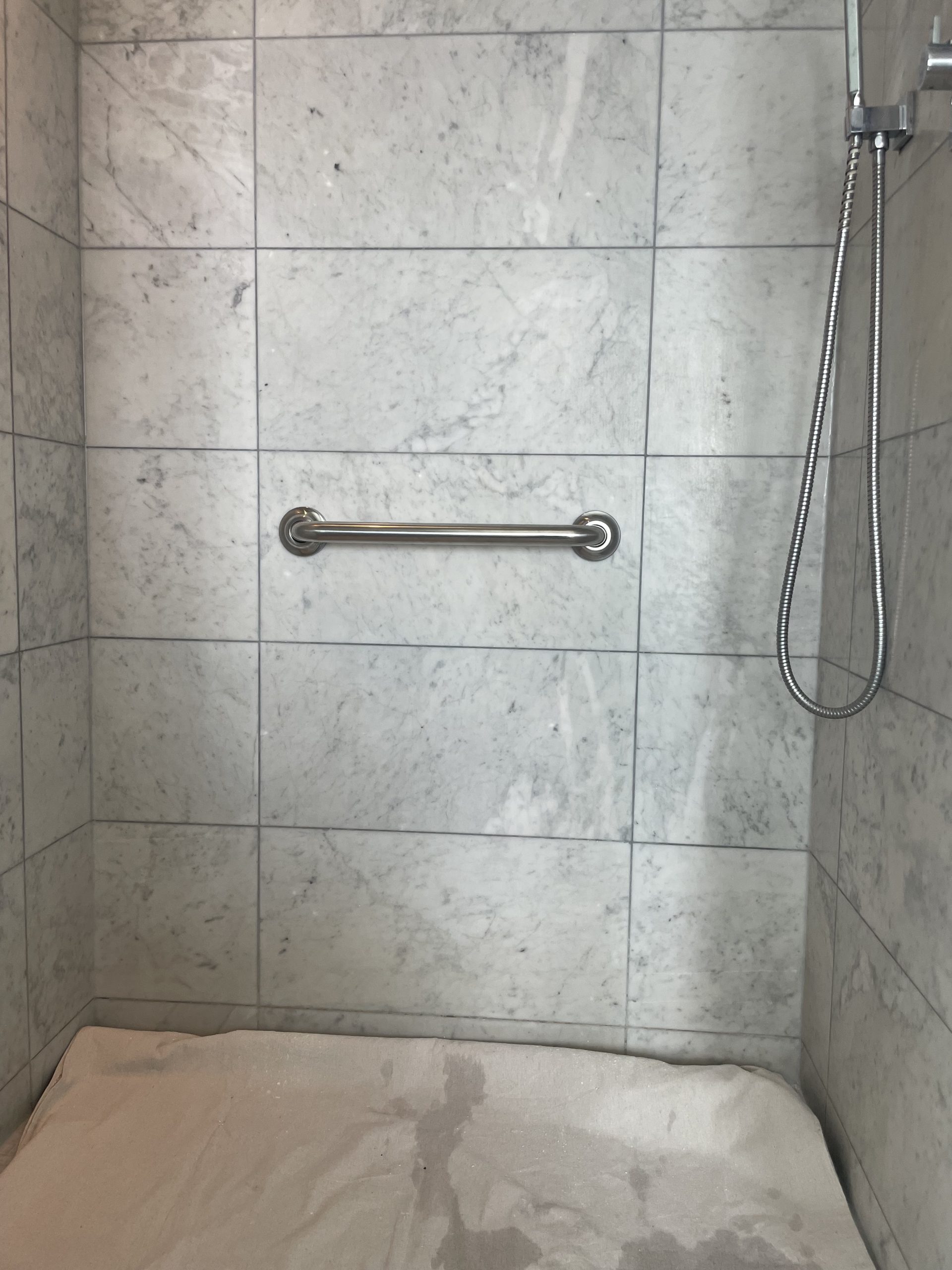 Grab bar installed to wet-area standard — secure, flush, and cleanly finished through tile.