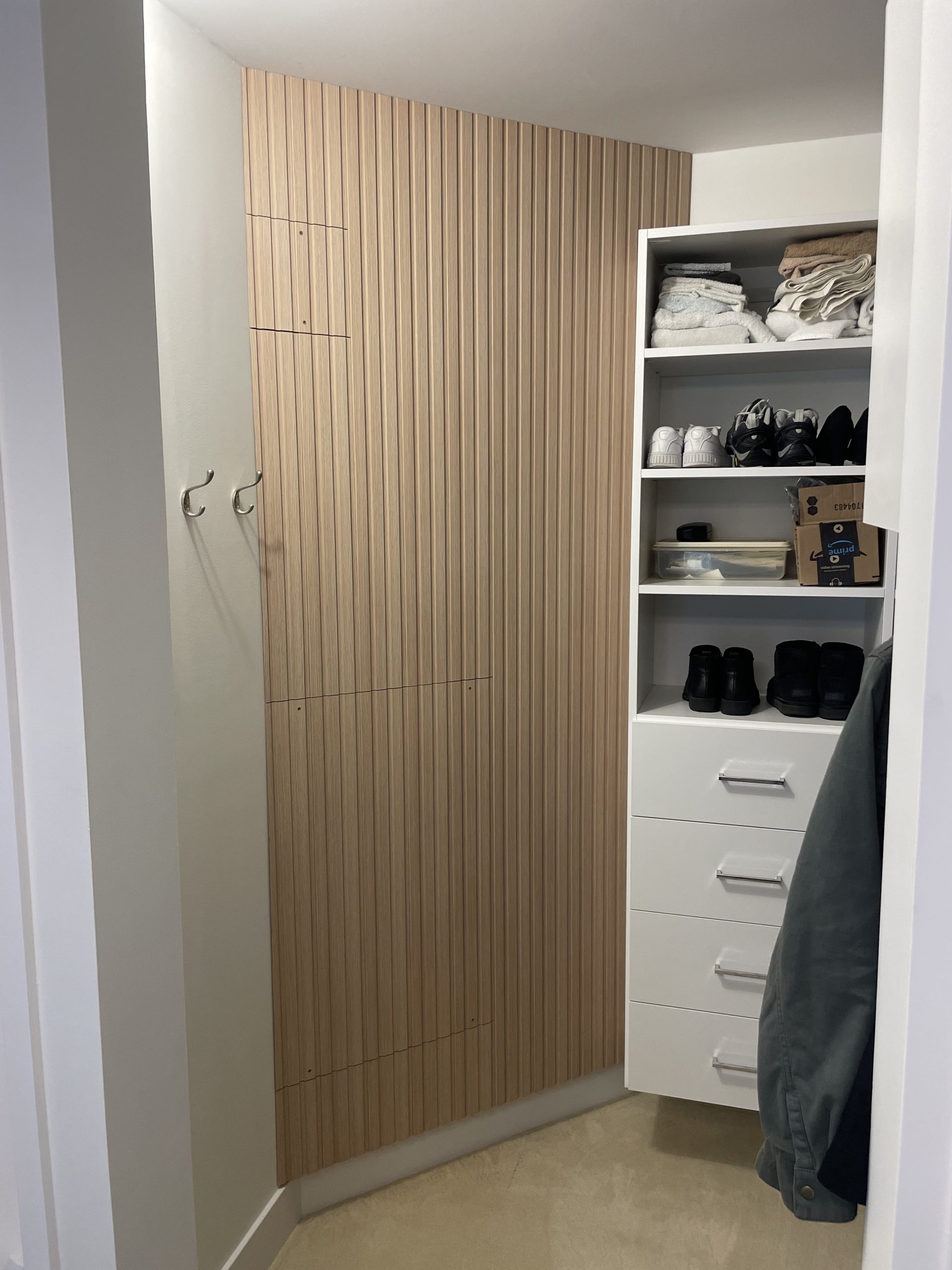 Custom wood slat feature wall designed and built to conceal existing utilities — transforming a functional wall into a clean, architectural interior detail.