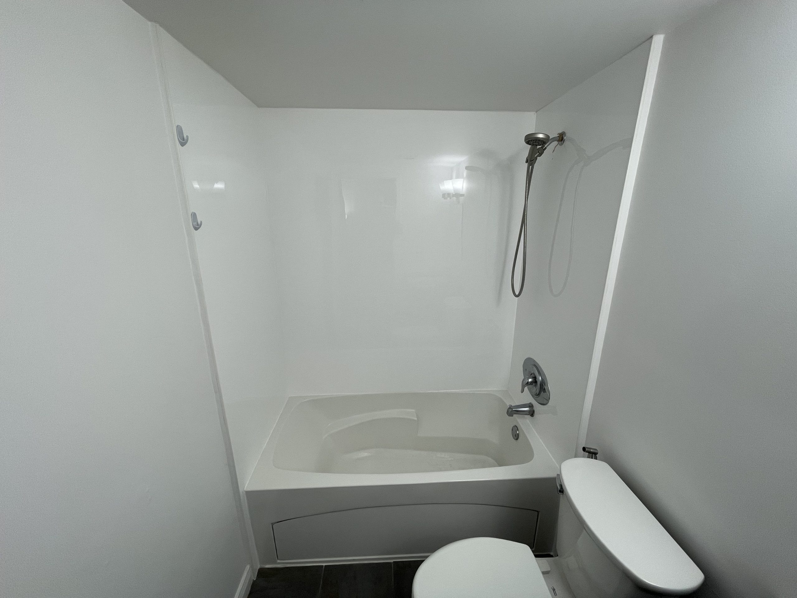 Complete bathroom refresh — new waterproof shower panels, seamless drywall, and a fresh coat of paint.