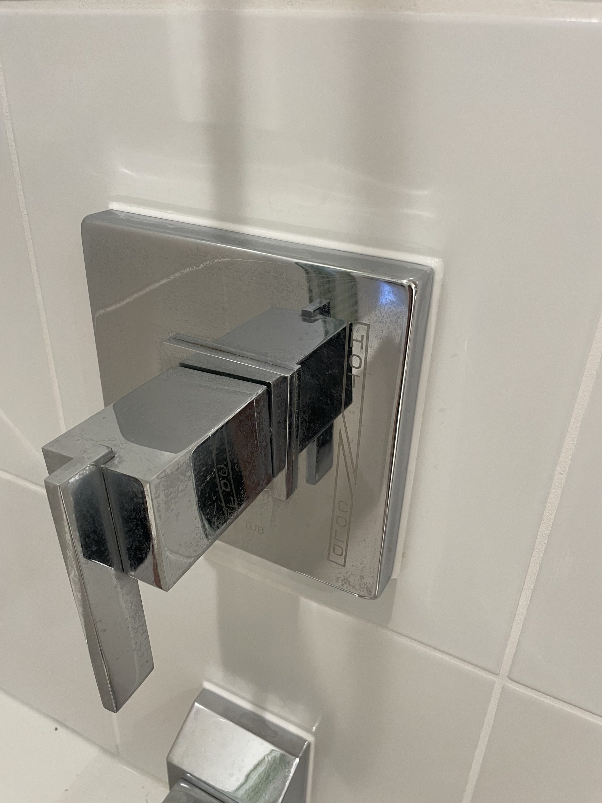 Deteriorated caulk removed and resealed around shower valve trim and tub spout — restoring a clean, watertight finish.
